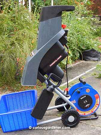 Ready for action - long extension cable to power the machine, shredder with  handy black paddle to push through stubborn bits, and an empty basket to catch the shredded materials.